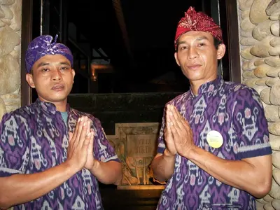 two men in purple shirts standing with their hands folded at Villa Cantik Tresna in Seminyak