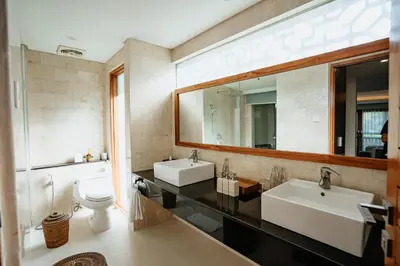 a bathroom with two sinks and a mirror at Villa Kayu Raja in Seminyak