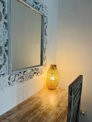a vase sitting on a table with a mirror at Pearl Boutique Hotel Adult only in Legian