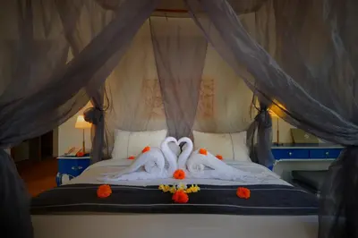 two swans made out of towels laying on a bed at Pearl Boutique Hotel Adult only in Legian