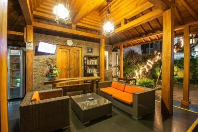 a living room with a couch and chairs and a tv at Surya Mas Villa in Legian