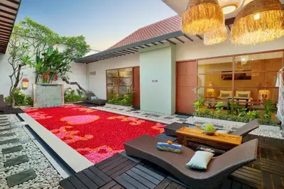 a patio with a red rug in front of a house at The Vie Villa Legian in Legian