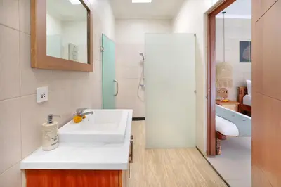 a white bathroom with a sink and a tub at The Vie Villa Legian in Legian