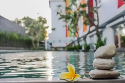 a stack of rocks next to a pool with a flower at Zuri Express Jimbaran in Jimbaran