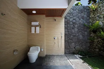 a bathroom with a toilet and a walk in shower at Del Cielo Villa Jimbaran in Jimbaran