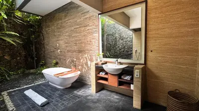a bathroom with a tub and a toilet and a sink at Del Cielo Villa Jimbaran in Jimbaran