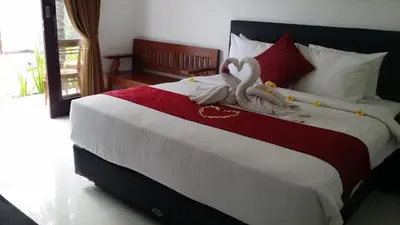 a bedroom with a bed with a stuffed animal on it at Palm Bamboo Hotel in Nusa Dua