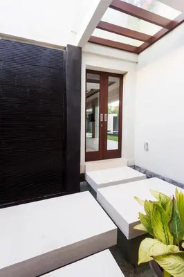 an empty room with a door and a plant at Villa by the Beach in Jimbaran