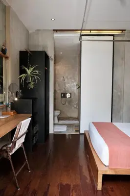 a bedroom with a bed and a desk and a bathroom at Villa Alina in Seminyak