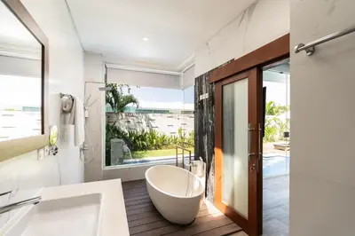 a bathroom with a tub and a large window at The Daha Luxury Villas in Seminyak