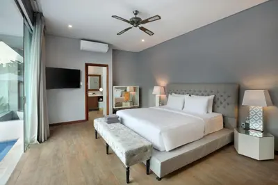 a bedroom with a large white bed and a couch at The Daha Luxury Villas in Seminyak