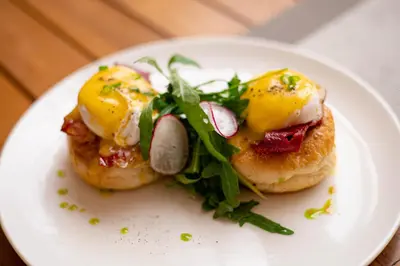 a white plate with two eggs on top of food at The Daha Luxury Villas in Seminyak