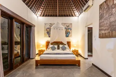 a bedroom with a bed with a canopy at Villa Tiga Mangga by Optimum Bali Villas in Seminyak