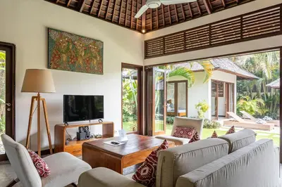 a living room with a couch and a tv at Villa Tiga Mangga by Optimum Bali Villas in Seminyak