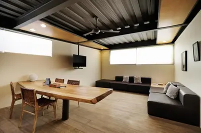 a living room with a wooden table and a couch at Clio Apartment in Seminyak