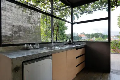 a kitchen with a sink and a large window at Clio Apartment in Seminyak