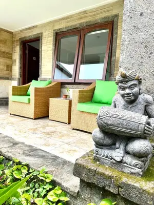 a statue of a boy sitting on a patio at Ellies Hotel in Nusa Dua