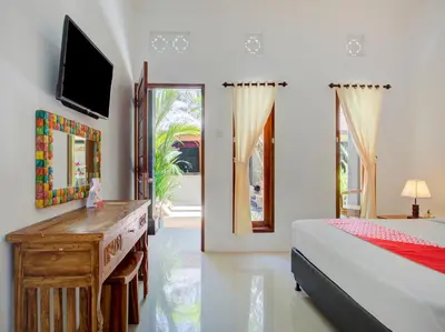a bedroom with a bed and a dresser and a mirror at Vivaldi Jimbaran in Jimbaran