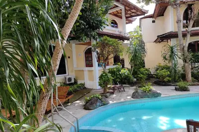 a house with a swimming pool in front of a house at Villa Puri Royan Jimbaran in Jimbaran