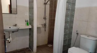 a bathroom with a shower and a toilet and a sink at Villa Puri Royan Jimbaran in Jimbaran