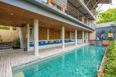 a large swimming pool in the middle of a building at Maca Villas and Residence Umalas in Seminyak