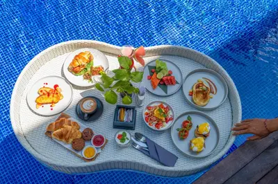 a round table with plates of food on it at Maca Villas and Residence Umalas in Seminyak