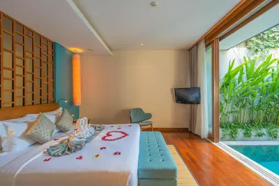 a bedroom with a bed and a tv and a pool at Maca Villas and Residence Umalas in Seminyak