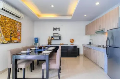 a kitchen with a dining table and a refrigerator at Private 2 Bed Pool Villa in Bustling Petitenget in Seminyak