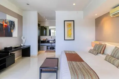 a bedroom with a large bed and a kitchen at Private 2 Bed Pool Villa in Bustling Petitenget in Seminyak