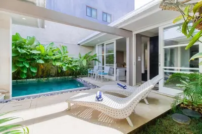 a patio with two chairs and a swimming pool at Private 2 Bed Pool Villa in Bustling Petitenget in Seminyak
