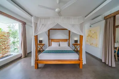 a bedroom with a bed with a canopy at Villa Paloma - Chic Tropical Garden Villa with Outdoor Pool in Seminyak