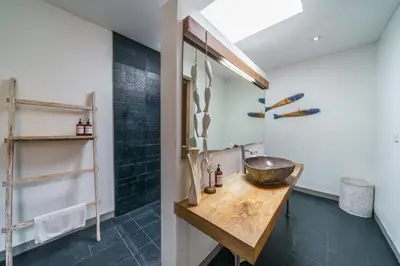 a bathroom with a wooden sink and a mirror at Villa Paloma - Chic Tropical Garden Villa with Outdoor Pool in Seminyak