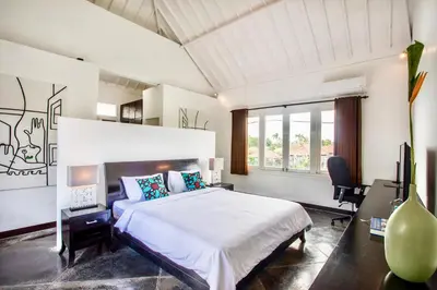 a bedroom with a large white bed and a desk at Villa JULIA | heart of Seminyak | 350m Beach in Seminyak