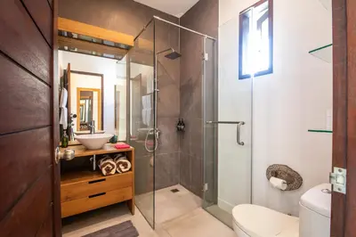a bathroom with a glass shower and a toilet at Villa Alissa in Seminyak