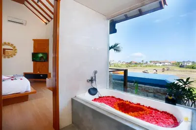 a bathtub filled with red flowers in a bedroom at The Wina Villa Seminyak by The Wina Resorts in Seminyak