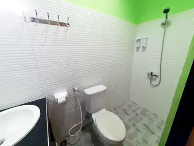 a bathroom with a white toilet and a sink at The Legian 777 in Legian