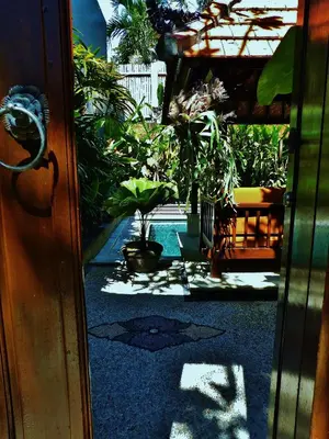 an open door to a patio with plants and a pool at Villa Kora in Seminyak