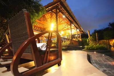 a couple of chairs on a patio at night at Sanur Seaview Hotel in Sanur