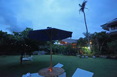 a table with an umbrella on a lawn at Sanur Seaview Hotel in Sanur