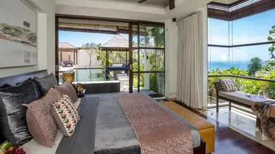 a bedroom with a bed and a view of the ocean at Villa Adenium by Elite Havens in Jimbaran