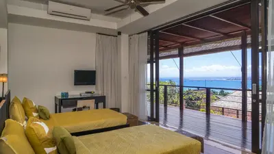 a bedroom with a balcony with a view of the ocean at Villa Adenium by Elite Havens in Jimbaran