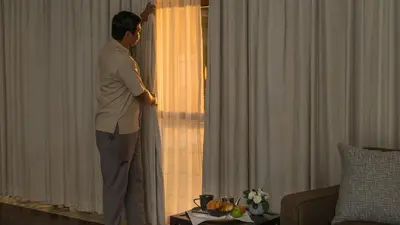 a man standing in a room looking out the window at Villa Adenium by Elite Havens in Jimbaran