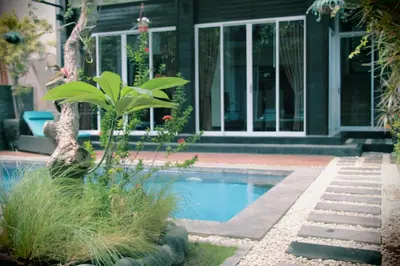a swimming pool in front of a house at The Nakula Villas in Legian