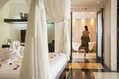 a woman in a bathroom looking at herself in the mirror at Villa Air Bali Boutique Resort and Spa in Seminyak