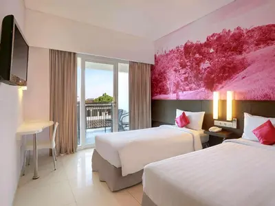 a hotel room with two beds and a balcony at Primera Hotel Seminyak in Seminyak