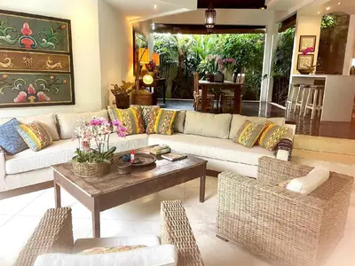 a living room with a couch and a table and chairs at Villa Sahaja in Canggu
