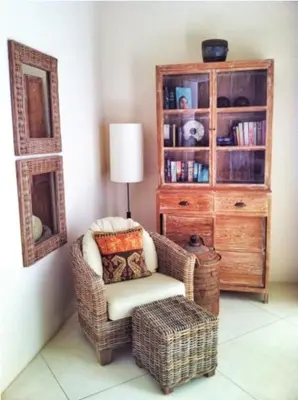 a living room with a chair and a book shelf at Villa Sahaja in Canggu