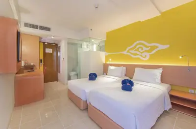 a hotel room with two beds and a bathroom at Kuta Beach Hotel in Kuta