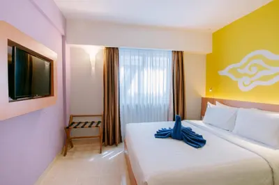 a bedroom with a large bed with a blue ribbon on it at Kuta Beach Hotel in Kuta