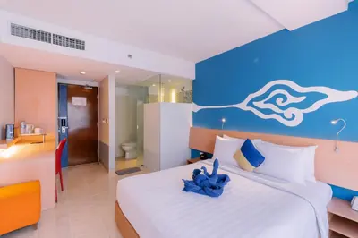 a bedroom with a large bed with a blue wall at Kuta Beach Hotel in Kuta